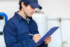 A man checks a clip board. How to Spot a Cracked Heat Exchanger.