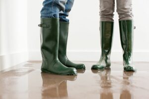People wear rain boots while standing in a puddle. Why Is My Furnace Leaking Water?
