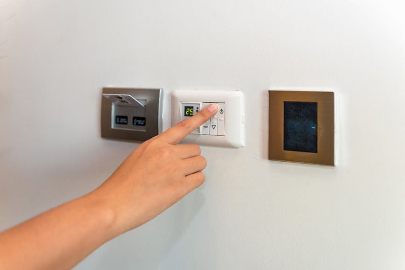 Person Adjusting Thermostat