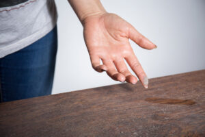 How to Eliminate Dust in My Home, Close-up of dust on woman finger taken from wooden table