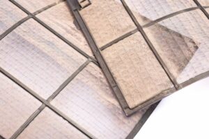 Replace Your Air Filter. Image is a photograph of a dirty air filter.